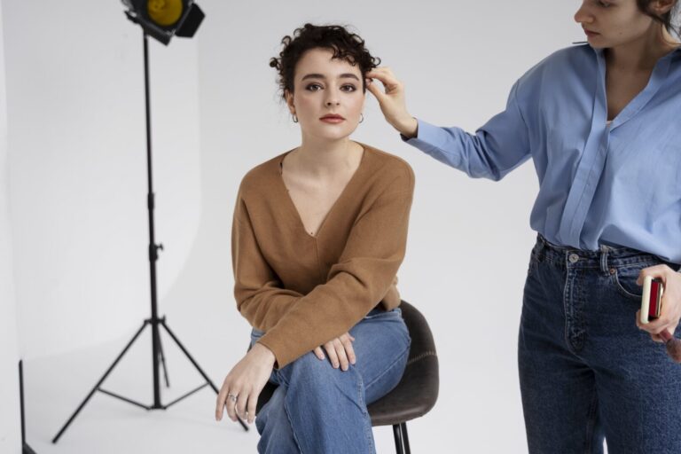 Makeup artist preparing a young model for a professional photoshoot -modeling agency portfolio session."
